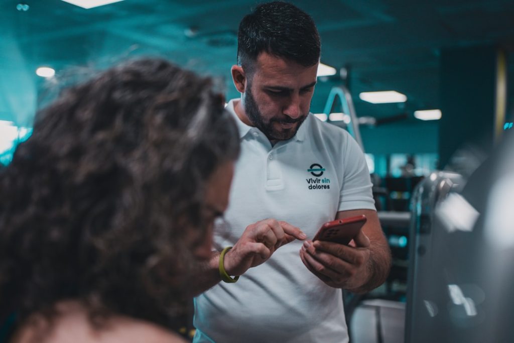 Sesión de entrenamiento en el gimnasio con un entrenador personal, enfocada en el rendimiento y el bienestar físico.